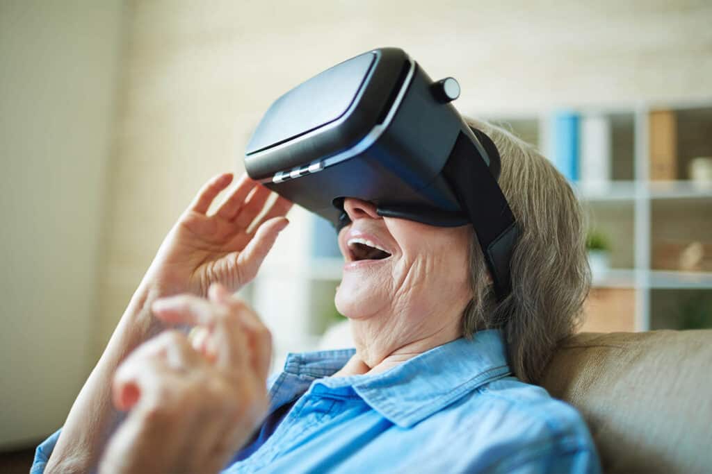 Senior smiling while looking through virtual reality goggles